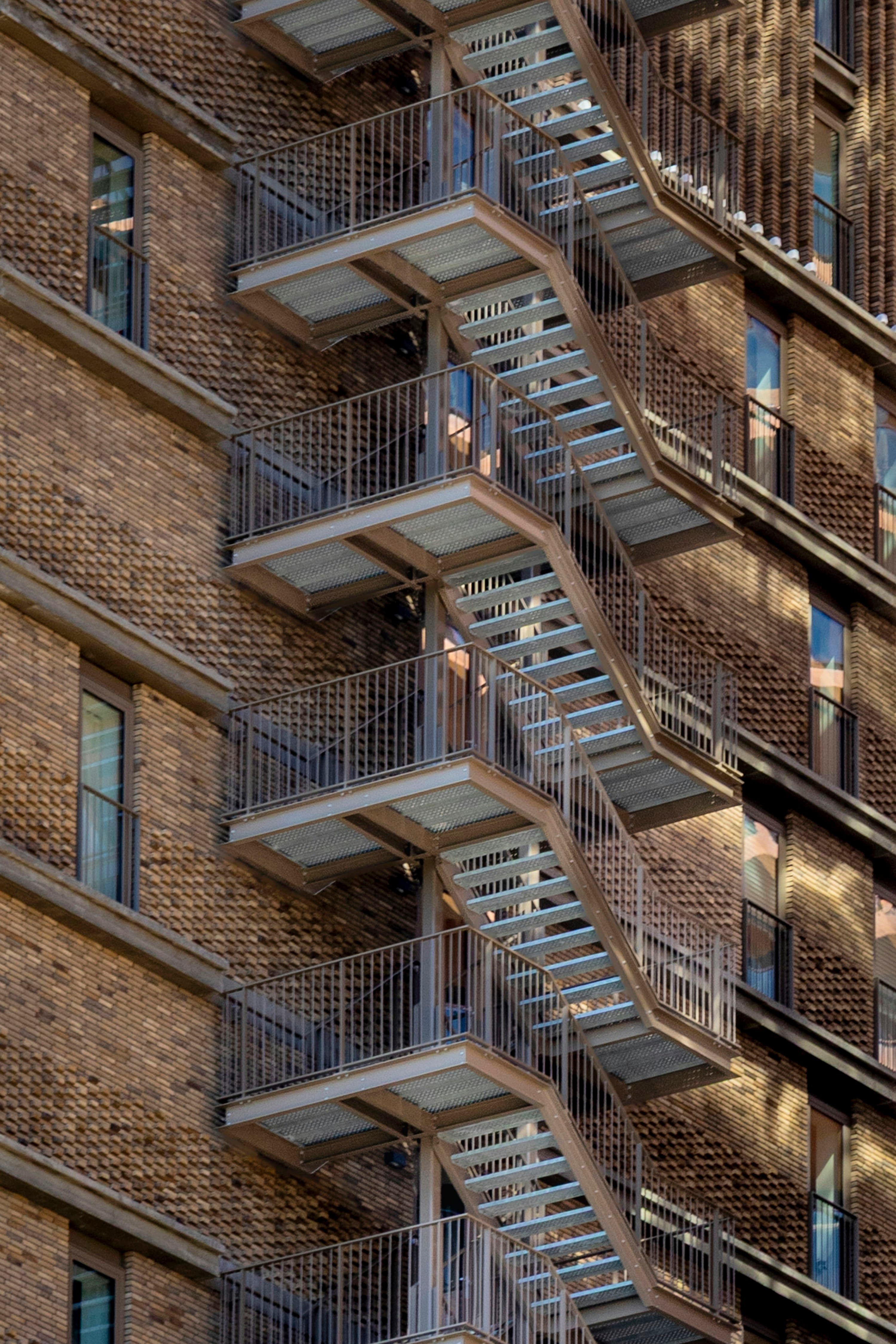 Brick apartment building with fire escape in an urban neighborhood