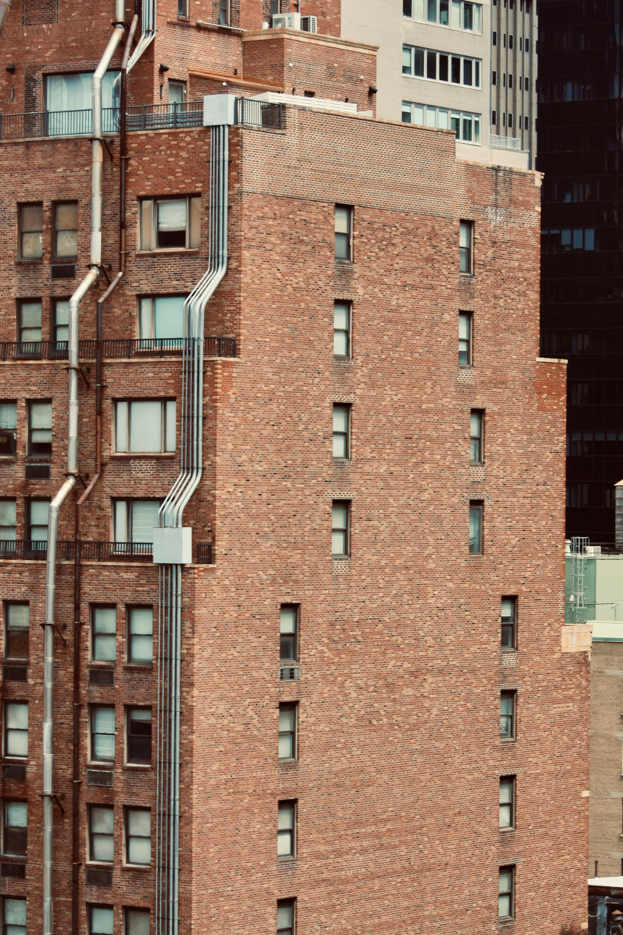 Tall brick residential buildings with rows of windows in an urban setting